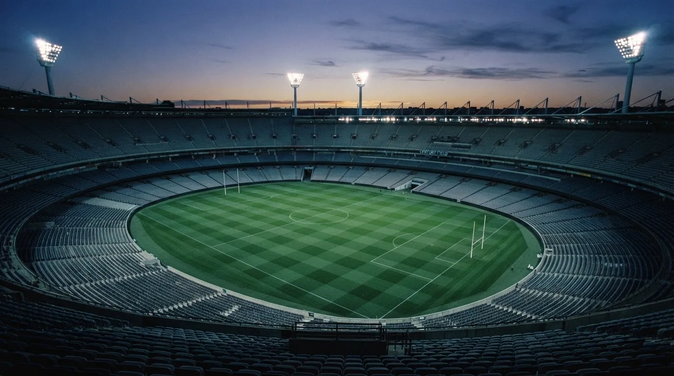 Een leeg voetbalstadion met lichtmasten bij schemering